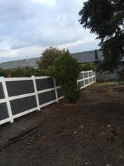 A Fence with grey painted panels and white painted rails and posts